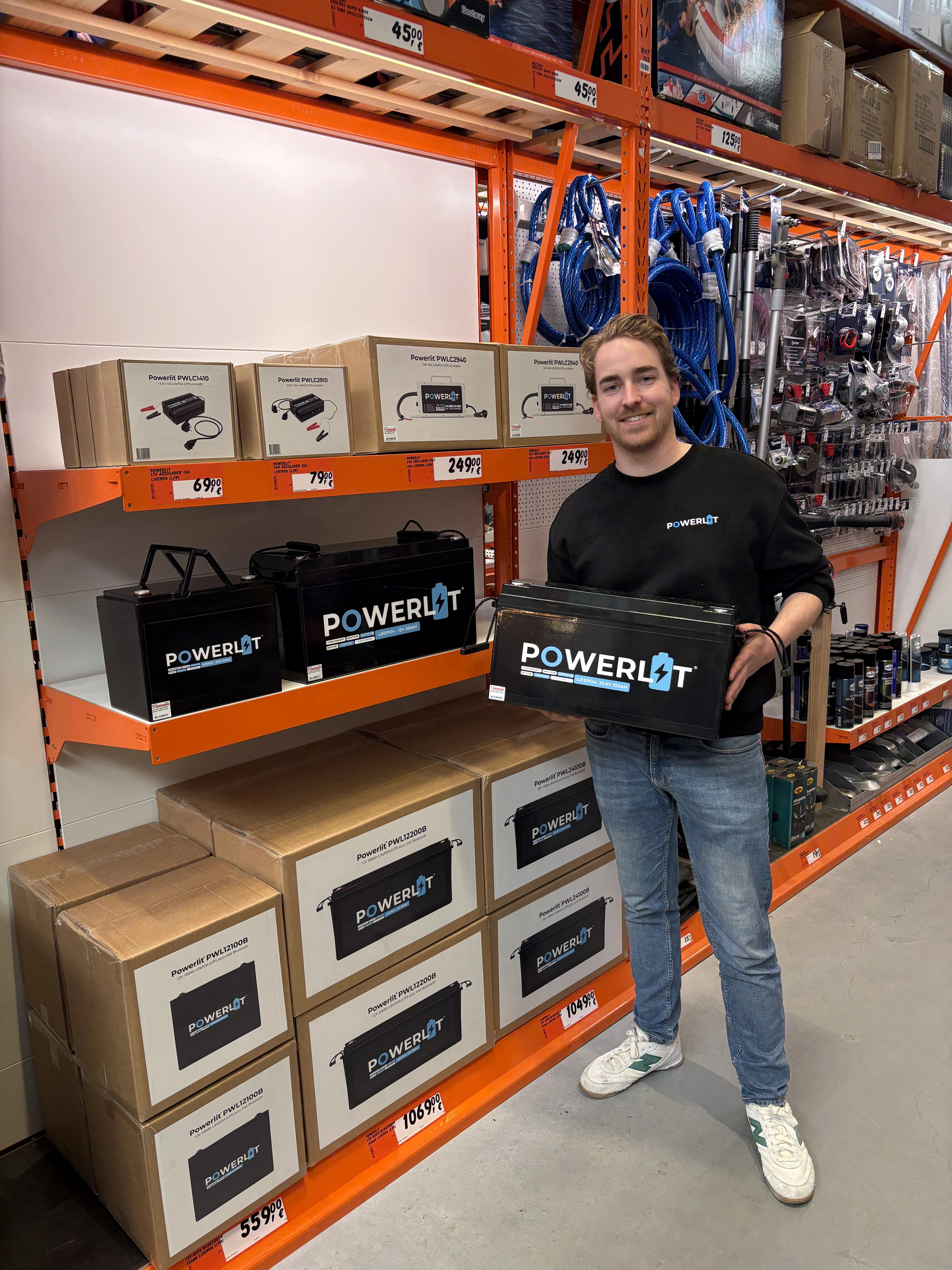 Powerlit medewerker bij Bauhaus met Powerlit accu in zijn hand